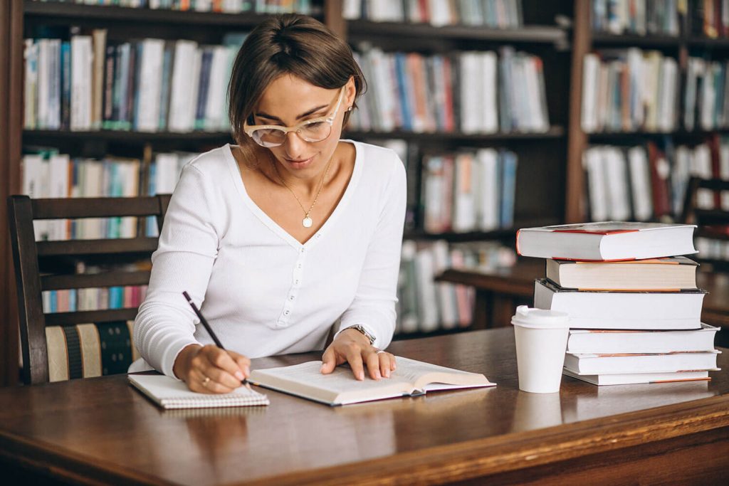 student-woman-studying-library-drinking-coffee